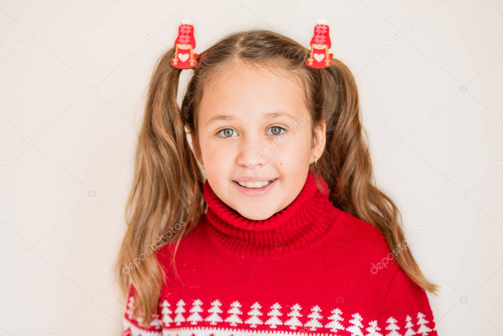 European Girl in Christmas sweater with Christmas ornaments on her ponytails