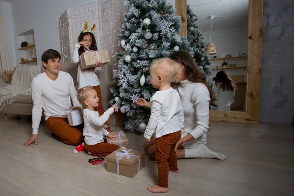 Famille européenne assise près de l'arbre de Noël avec des cadeaux — Photo
