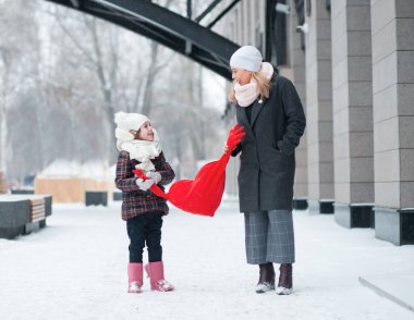 Küçük kız annesiyle gidiyor ve kalbi yumuşacık bir oyuncak tutuyor. Sevgililer Günü.