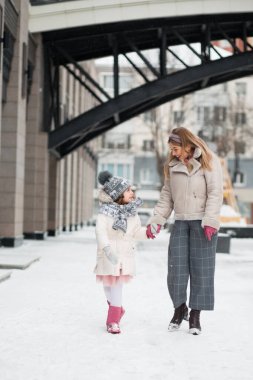 Küçük kız annesiyle kış şehrine gidiyor.