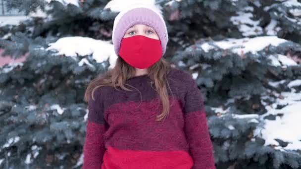 Biała dziewczynka w czerwonym swetrze i jaskrawej masce. Zima — Wideo stockowe