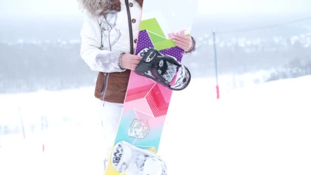 Sporda kıdemli bir kadın dağlarda duran snowboard 'lu bir elbise giyiyor. — Stok video