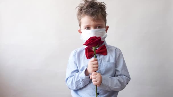 Netter Junge in Fliege mit roter Rose und schützender Gesichtsmaske. Valentin. covid — Stockvideo