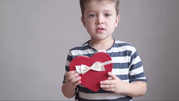 Cute boy taniec z czerwonym i białym sercem pudełko prezentów. Walentynki. — Wideo stockowe