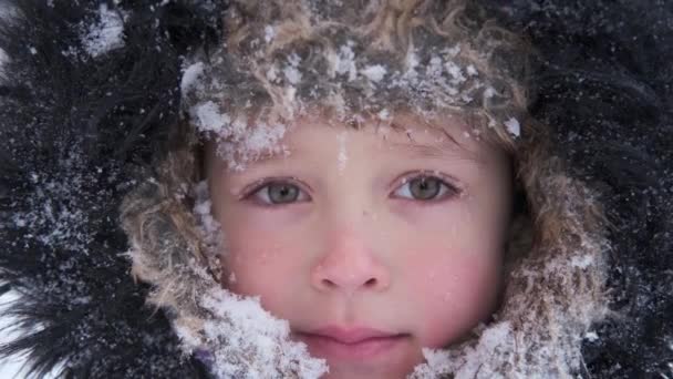 Little cute boy in winter hat with snowy face — Stock Video
