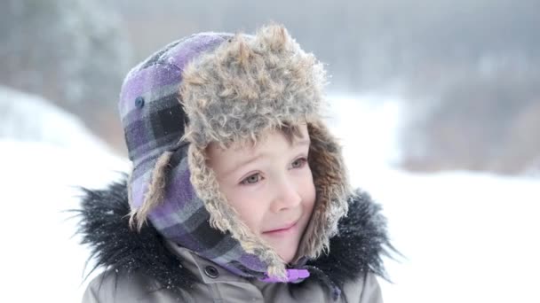 Pequeño sonriente caucásico lindo chico en invierno sombrero, chaqueta en invierno — Vídeo de stock