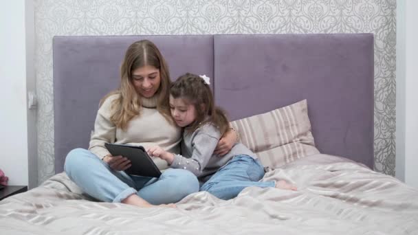 Blank klein meisje met moeder die de buik van de zwangerschap aanraakt met tablet — Stockvideo
