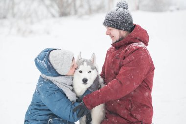 Genç çift kışın Sibirya kabuğunu kucaklıyor. Sevgililer Günü. Köpek..