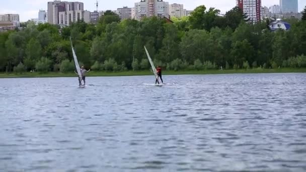 Ufa, Russia, june, 12, 2019. active senior people swim on windsurfing in lake. — Stock Video
