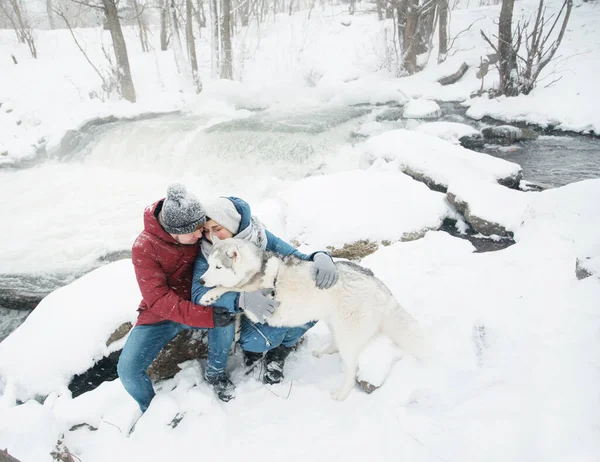 Casal abraçando e sentado com cão husky siberiano no inverno. Dia dos namorados. — Fotografia de Stock