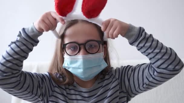 4k. маленька вимерла дівчинка в обличчі захисна маска в вухах кролика. Великодня — стокове відео