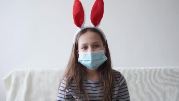 4k. petite fille mignonne dans le masque de protection du visage dans les oreilles de lapin. Pâques — Video