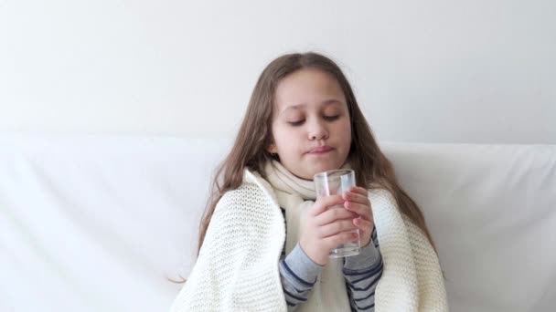 4k. Χαριτωμένο κορίτσι του δημοτικού με γρίπη στο σπίτι. Πιες ένα ποτήρι νερό. — Αρχείο Βίντεο