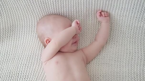 4k. Joli petit garçon mignon allongé sur un plaid blanc. Famille heureuse — Video