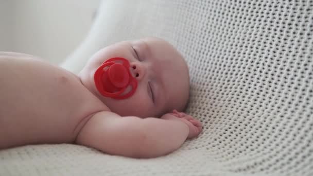 4k. Aranyos, csinos kisfiú, fehér kockás ágyon alszik. Boldog család. — Stock videók