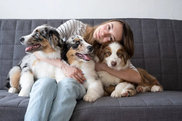 Atractiva mujer feliz abrazo tres colores merle perro pastor australiano —  Fotos de Stock