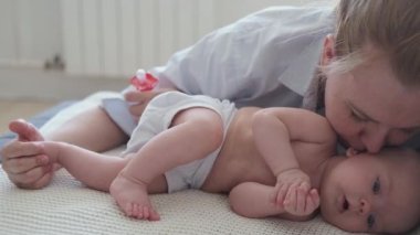 4 bin. Çekici, mutlu bir anne öpücüğü. Küçük bebekle yatıyor. Mutlu aile