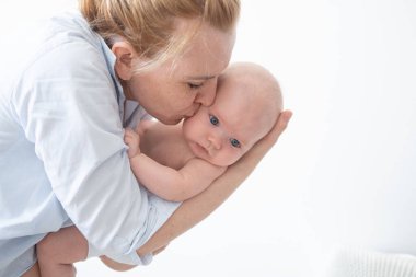 Çekici, mutlu anne, küçük bebeğini öp. Doğum. Mutlu aile