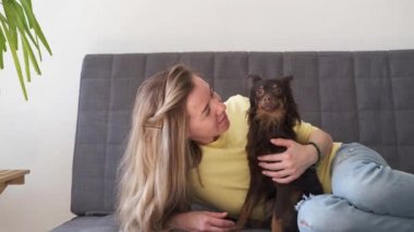 4 bin. Kanepede komik kahverengi Rus oyuncak teriyeriyle yatan mutlu sarışın kadın.