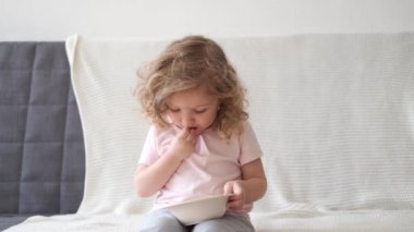 4 bin. Kıvırcık güzel kız açık gri arka planda elma yiyor.
