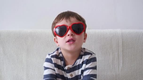 4k. Funny little cute boy in heart glasses. Valentine day. — Stock Video