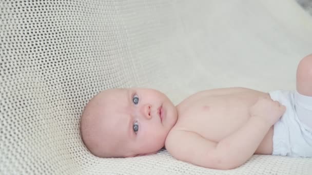 4k. Cute pretty little baby boy lying on white plaid. Happy family — Stock Video
