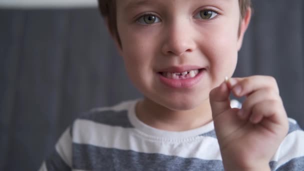 4k. kleine blanke jongen tonen eerste ontbrekende melktanden — Stockvideo