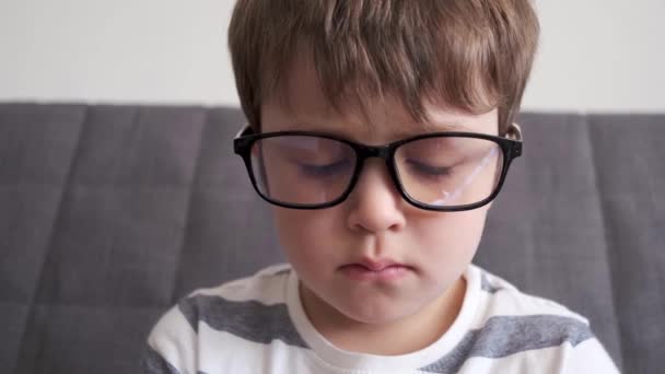 4k. liten söt kaukasiska pojke i glasögon på nära håll — Stockvideo