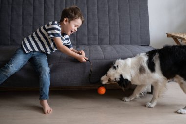 little happy boy play with Australian shepherd dog ball