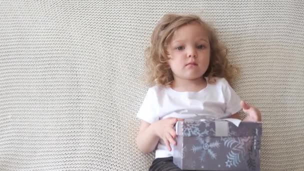 4k. Menina bebê encaracolado bonito com presente de Natal — Vídeo de Stock
