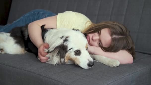 Aantrekkelijke vrouw huisdier liggend met blauwe merle Australische herder hond — Stockvideo