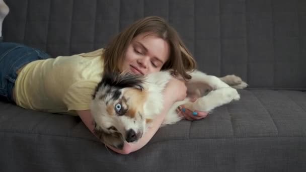 Atractiva mujer abrazo acostado con azul merle perro pastor australiano — Vídeo de stock