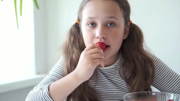 Menina bonita em t-shirts listradas comendo morango — Vídeo de Stock
