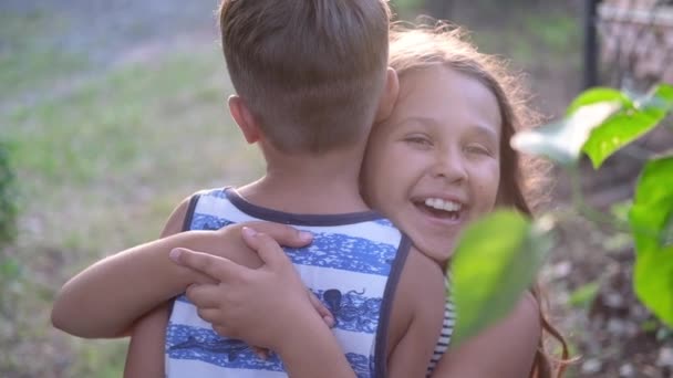 Hermano y hermana abrazan juntos al aire libre — Vídeos de Stock