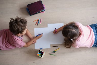 Sevimli kız ve oğlan evde çalışıyor, ödev yapıyor.