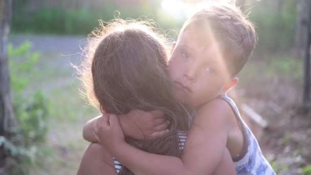 Hermano y hermana abrazan juntos al aire libre — Vídeos de Stock