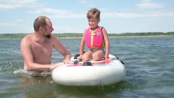 Ufa, Rusia, 13 de junio de 2021, feliz padre aprender hijo a montar en el surf — Vídeos de Stock