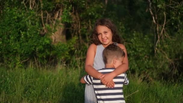 Veli ja sisko halata yhdessä ulkona — kuvapankkivideo