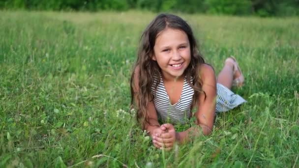 Mutlu küçük tatlı kız çimlerin üzerinde uzanıyor — Stok video