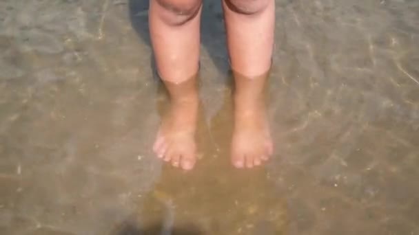 Kinderen benen in het water in het meer. Textuur van het water. — Stockvideo