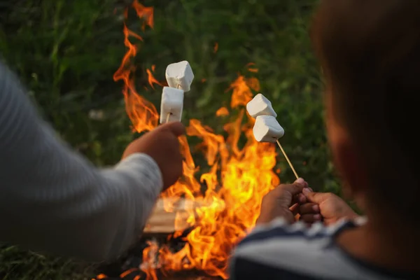 Two kids hands roasting marshmallow at campfire in forest — Stock Photo, Image