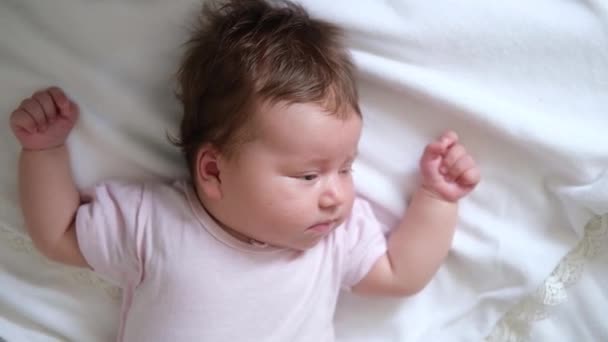 Linda niñita acostada durmiendo sobre cuadros blancos. Familia feliz — Vídeos de Stock