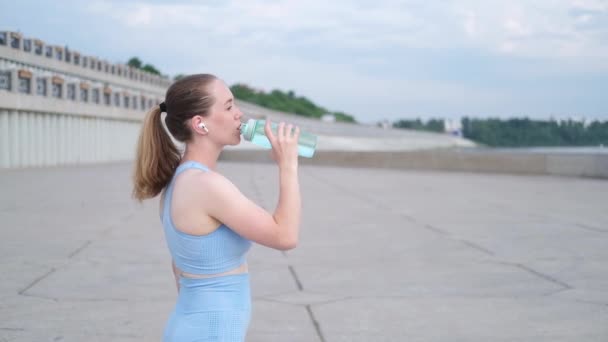 Jovem mulher fitness feliz terminar correndo, beber água na cidade — Vídeo de Stock