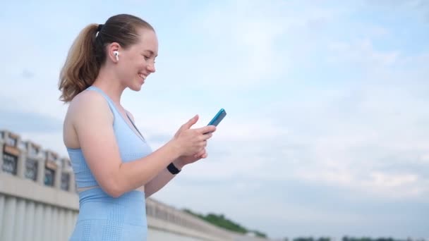 Jonge gelukkige fitness vrouw klaar met hardlopen in de stad — Stockvideo