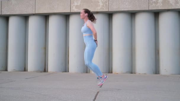 Joven mujer fitness feliz hacer ejercicio al aire libre en la ciudad — Vídeo de stock