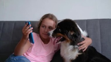 Küçük beyaz kız Avustralyalı çoban köpeğini kucaklıyor. Selfie yap.