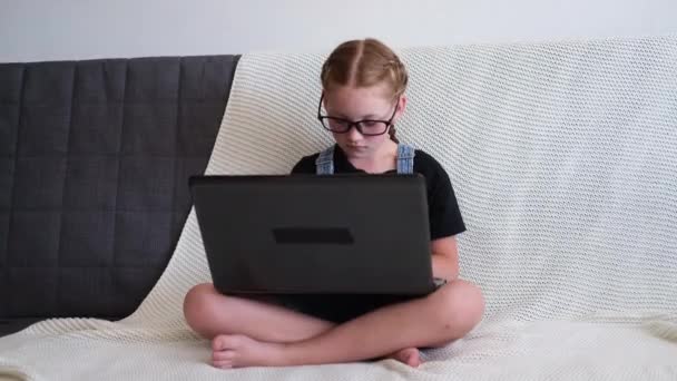 Caucasico rossa ragazza in occhiali utilizzando laptop studiare a casa — Video Stock