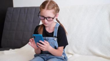  Kafkasyalı kızıl kız evde telefon kullanarak ders çalışıyor.
