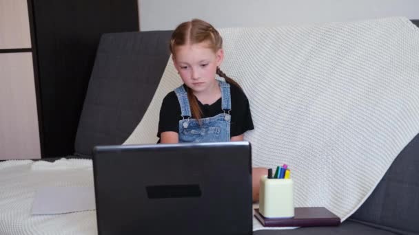 家庭でノートパソコンを使って勉強している白人の赤毛の女の子は — ストック動画