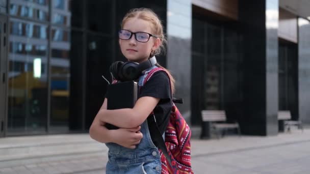 Słodkie biały ruda dziewczyna w okulary z książki i plecak — Wideo stockowe